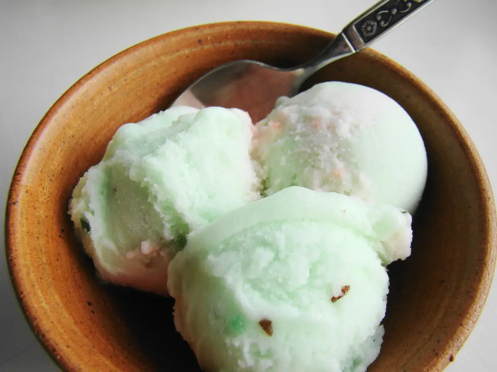 Scoops of pale green sorbet in a wooden bowl